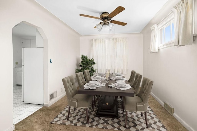 dining area with ceiling fan, visible vents, baseboards, and arched walkways
