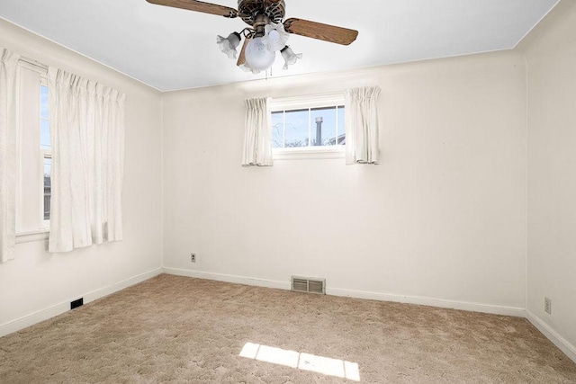spare room featuring visible vents, baseboards, ceiling fan, and carpet floors