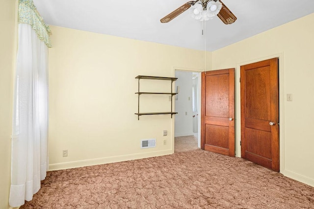 unfurnished bedroom with baseboards, visible vents, and carpet