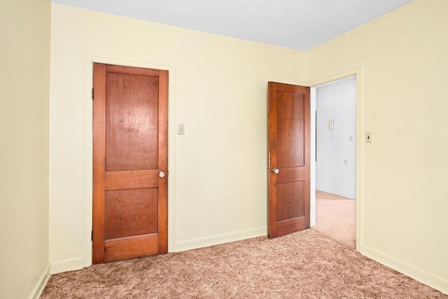 spare room with baseboards and carpet flooring