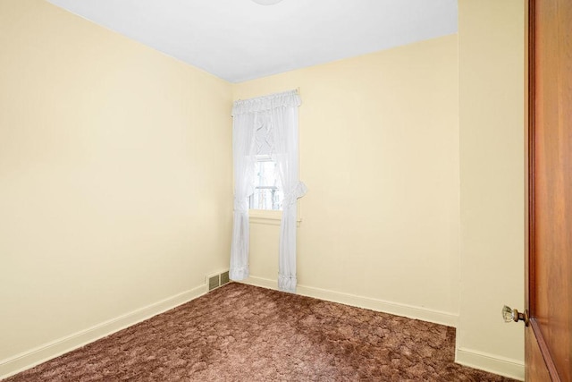 unfurnished room featuring visible vents, baseboards, and dark colored carpet