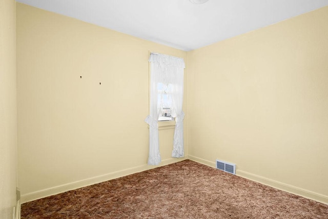 empty room featuring carpet flooring, visible vents, and baseboards