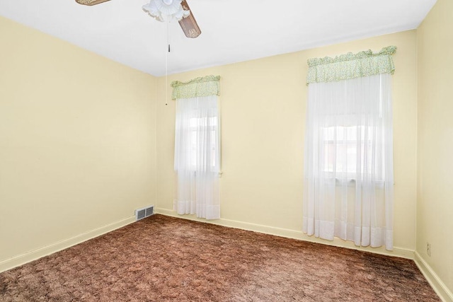 spare room with baseboards, ceiling fan, visible vents, and carpet floors