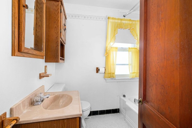 bathroom with toilet, tile patterned floors, vanity, and a bathing tub