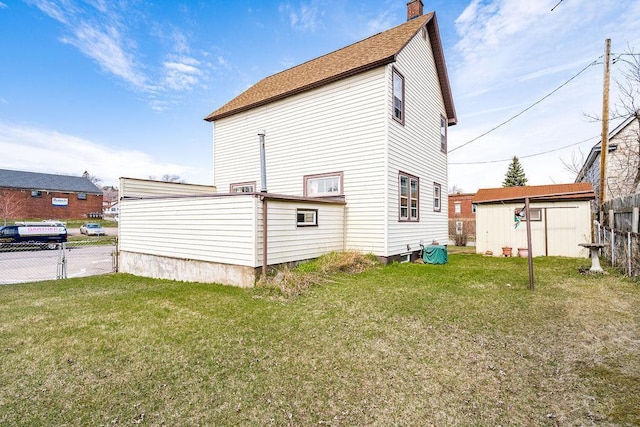 back of house featuring a yard, fence, a shingled roof, and a chimney