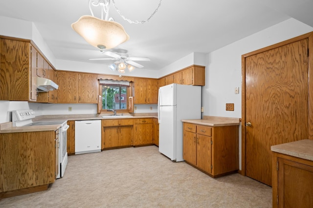 615 9th Ave SW, Faribault, MN 55021 - kitchen featuring white appliances, under cabinet range hood, a sink, brown cabinets, and light flooring
