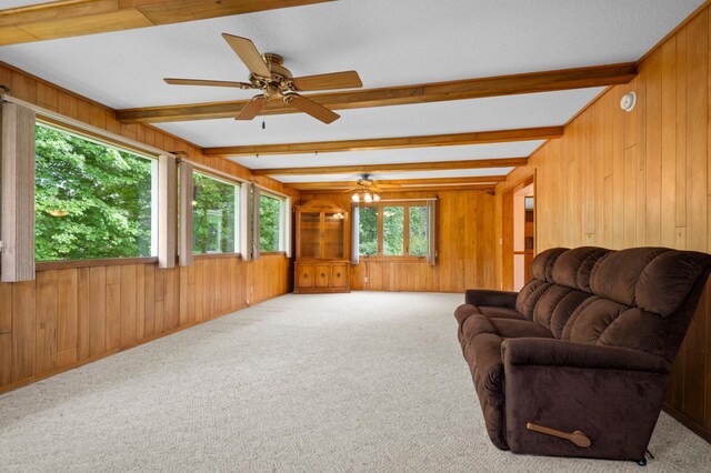 615 9th Ave SW, Faribault, MN 55021 - carpeted living room with wood walls, beamed ceiling, and a ceiling fan