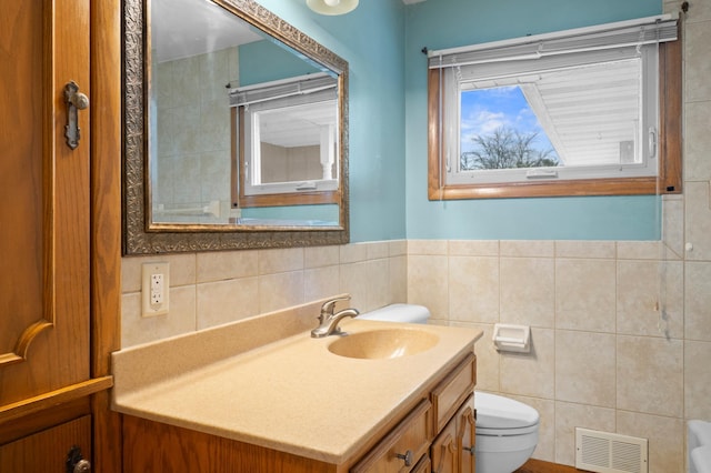 615 9th Ave SW, Faribault, MN 55021 - bathroom with tile walls, toilet, vanity, and a wainscoted wall