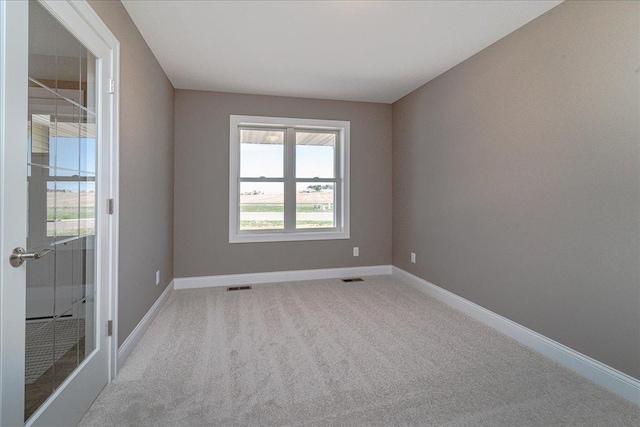 empty room with visible vents, carpet, and baseboards