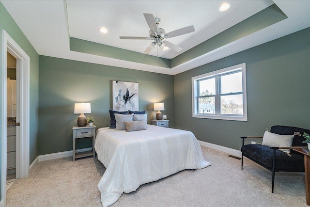 bedroom featuring light carpet, a raised ceiling, recessed lighting, baseboards, and visible vents