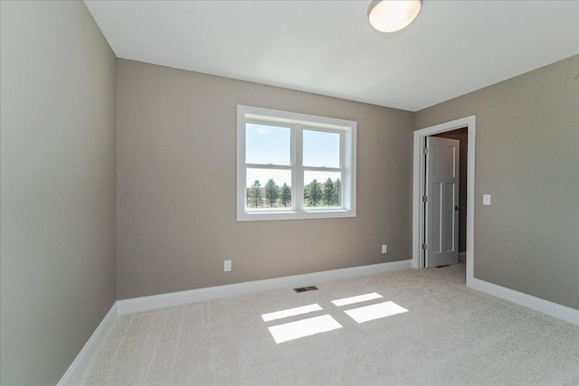 unfurnished room with visible vents, baseboards, and light carpet