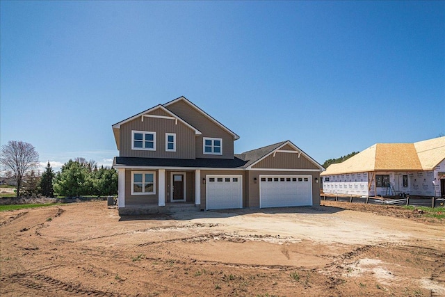 craftsman inspired home with board and batten siding, an attached garage, fence, and dirt driveway