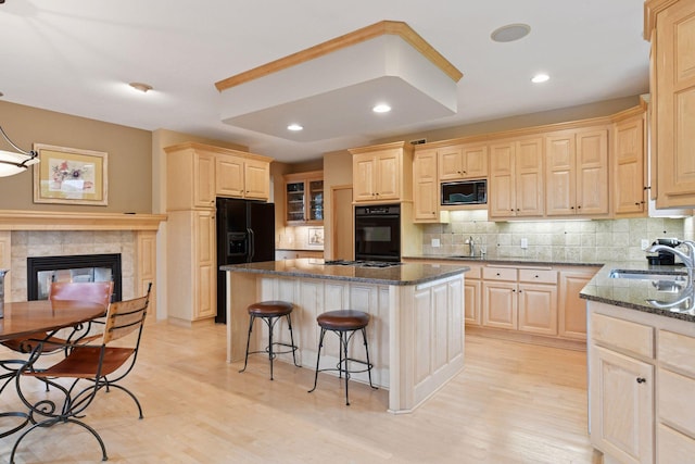 809 Saint Moritz, Victoria, MN 55386 - kitchen with light brown cabinetry, black appliances, a sink, a kitchen breakfast bar, and recessed lighting