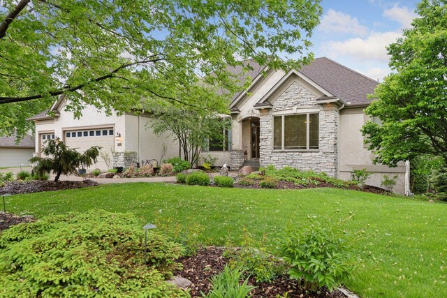 809 Saint Moritz, Victoria, MN 55386 - view of front of home featuring stone siding, stucco siding, a front lawn, an attached garage, and roof with shingles