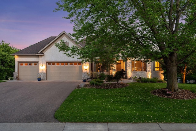 809 Saint Moritz, Victoria, MN 55386 - view of front of house with stone siding, stucco siding, driveway, an attached garage, and a yard