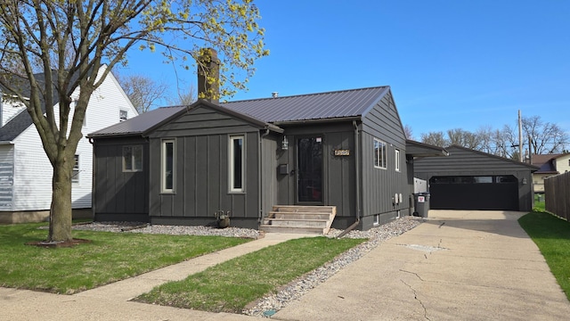 view of front of home featuring a garage, board and batten siding, concrete driveway, and metal roof