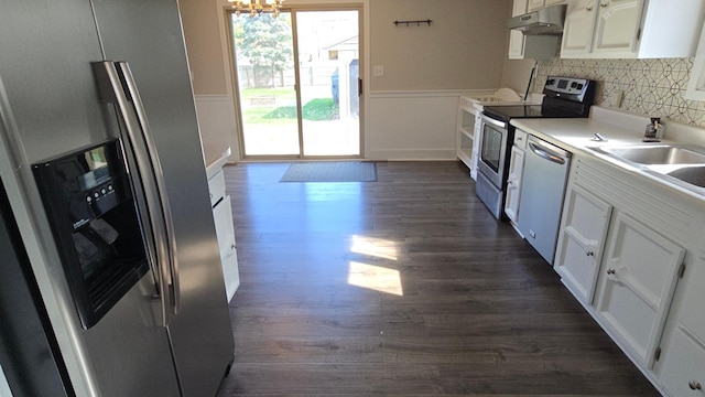kitchen with dark wood-style flooring, a notable chandelier, stainless steel appliances, white cabinetry, and under cabinet range hood