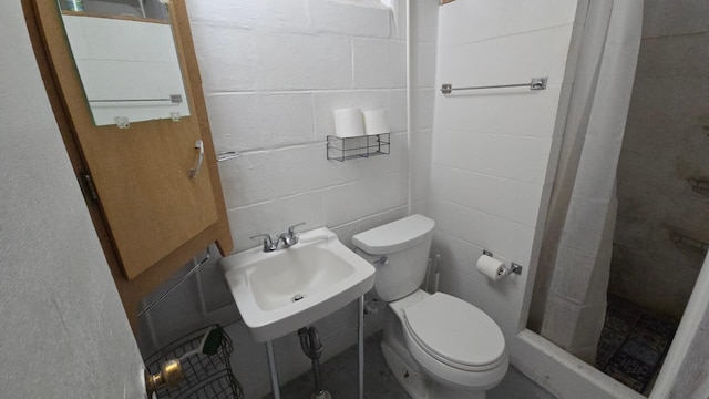 bathroom featuring a sink, a stall shower, and toilet