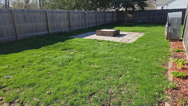 view of yard with a fenced backyard, a patio area, and an outdoor fire pit