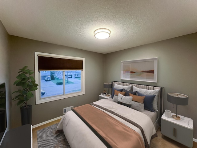 carpeted bedroom featuring visible vents, a textured ceiling, and baseboards