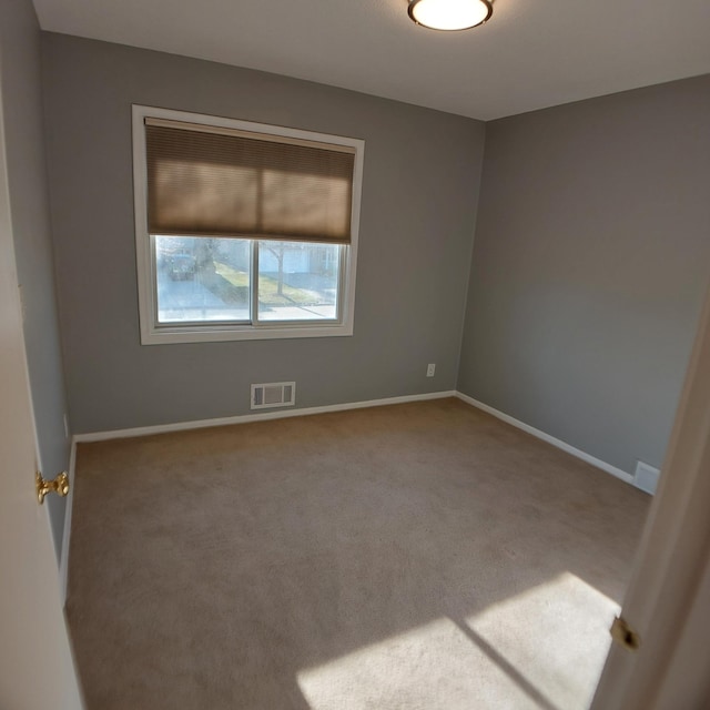 spare room featuring baseboards, carpet, and visible vents