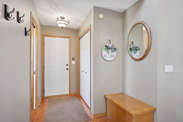 2797 Ocarina Dr, Sauk Rapids, MN 56379 - doorway to outside featuring baseboards, a textured ceiling, and light wood-style flooring