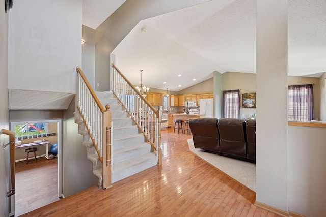 2797 Ocarina Dr, Sauk Rapids, MN 56379 - stairway featuring lofted ceiling, a chandelier, and hardwood / wood-style flooring
