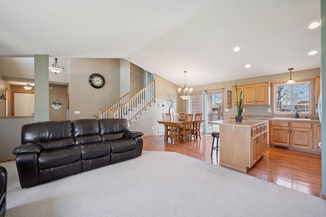 2797 Ocarina Dr, Sauk Rapids, MN 56379 - living room featuring a notable chandelier, light carpet, baseboards, vaulted ceiling, and stairway