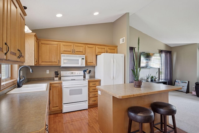 2797 Ocarina Dr, Sauk Rapids, MN 56379 - kitchen featuring a sink, white appliances, a kitchen breakfast bar, light wood-style flooring, and visible vents