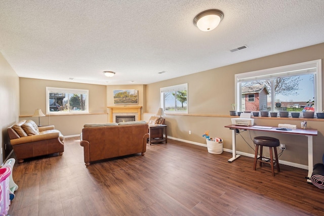 2797 Ocarina Dr, Sauk Rapids, MN 56379 - home office featuring a textured ceiling, visible vents, a tile fireplace, wood finished floors, and baseboards