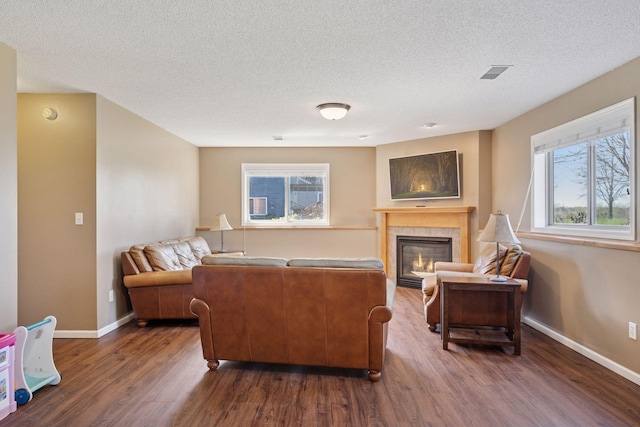 2797 Ocarina Dr, Sauk Rapids, MN 56379 - living area with dark wood-style flooring, a fireplace, a textured ceiling, baseboards, and visible vents