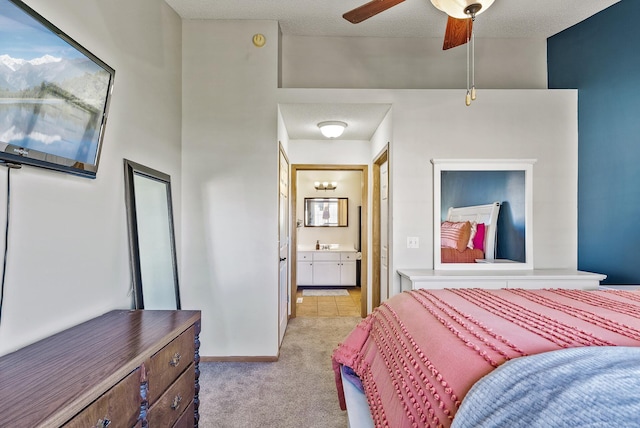 bedroom with connected bathroom, baseboards, light carpet, and ceiling fan