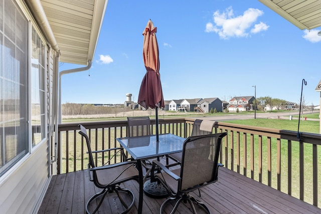 deck featuring a residential view, outdoor dining area, and a yard