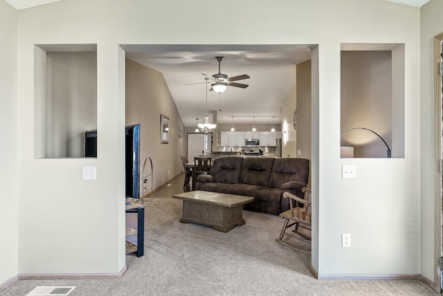 carpeted living room with baseboards, ceiling fan with notable chandelier, and lofted ceiling