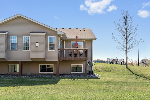 rear view of house featuring a lawn and a balcony