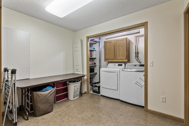 washroom with cabinet space, independent washer and dryer, and a textured ceiling