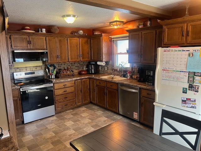 822 Holcombe Ave N, Litchfield, MN 55355 - kitchen featuring dark countertops, appliances with stainless steel finishes, decorative backsplash, and a sink