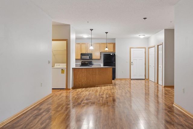 2530 34th St Unit 111, Minneapolis, MN 55406 - kitchen featuring washer / clothes dryer, black appliances, light wood-style floors, and baseboards