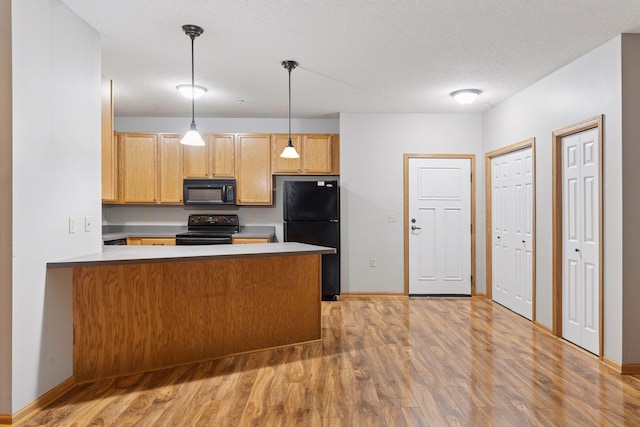 2530 34th St Unit 111, Minneapolis, MN 55406 - kitchen with black appliances, a peninsula, light wood finished floors, pendant lighting, and a textured ceiling