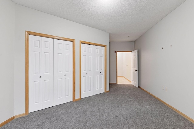 2530 34th St Unit 111, Minneapolis, MN 55406 - unfurnished bedroom with two closets, carpet floors, a textured ceiling, and baseboards