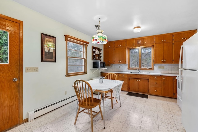 kitchen featuring brown cabinets, a sink, light countertops, freestanding refrigerator, and a baseboard heating unit