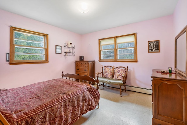 bedroom with baseboards, a baseboard heating unit, multiple windows, and light floors