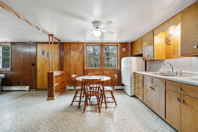 kitchen with ceiling fan, baseboard heating, light countertops, freestanding refrigerator, and light floors