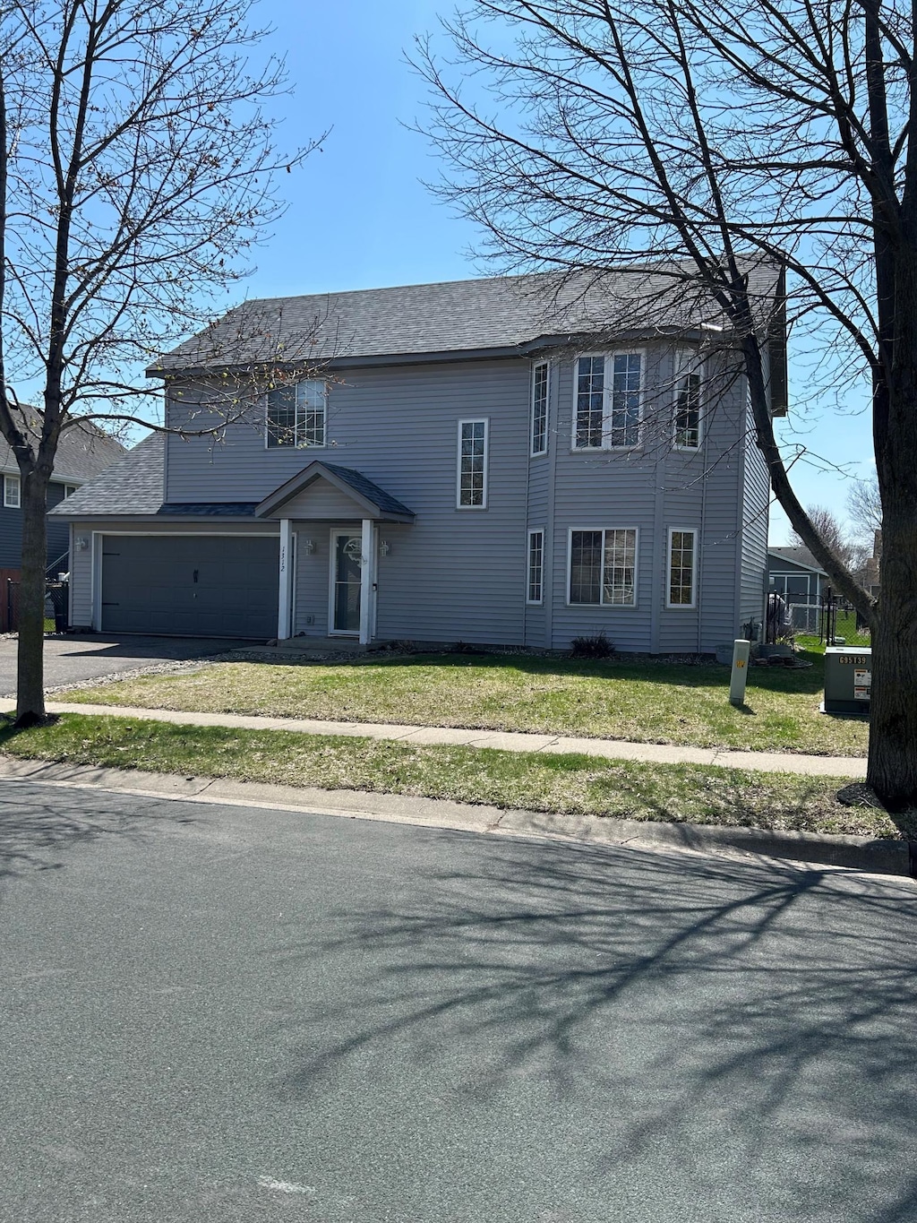 view of front facade featuring driveway, a front yard, and a garage