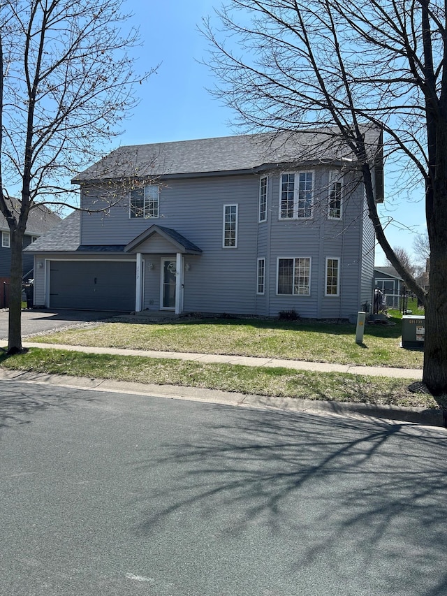 view of front facade featuring driveway, a front yard, and a garage