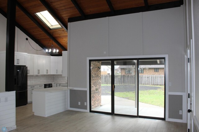 kitchen featuring a skylight, tasteful backsplash, beamed ceiling, wood ceiling, and black appliances