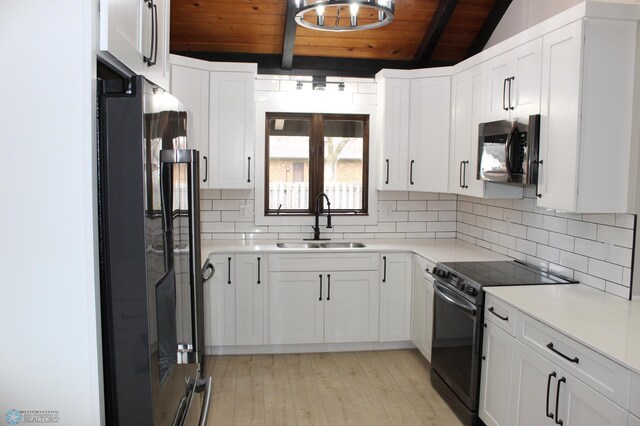 kitchen featuring white cabinetry, wooden ceiling, tasteful backsplash, a sink, and black appliances