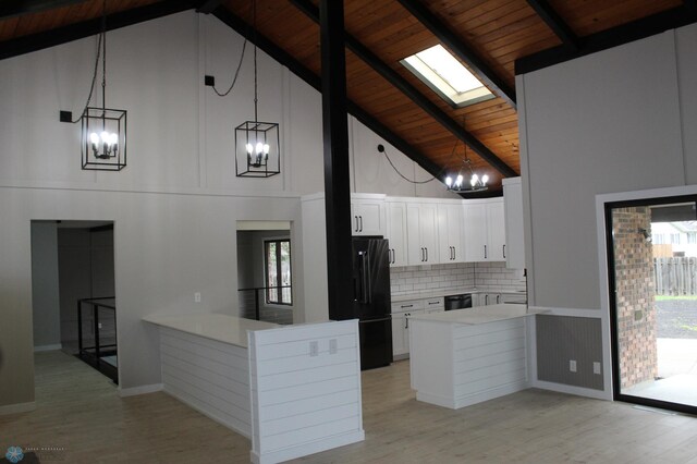 kitchen featuring an inviting chandelier, light wood-style floors, a peninsula, wood ceiling, and black appliances