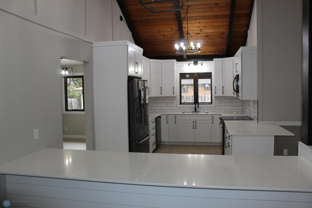 kitchen with tasteful backsplash, a sink, wooden ceiling, black appliances, and an inviting chandelier