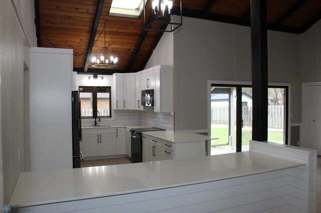 kitchen with a notable chandelier, a sink, backsplash, wood ceiling, and black appliances